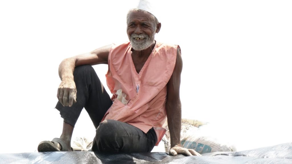 O Sr Gaikwad um agricultor indiano está observando a construção de seu reservatório de água