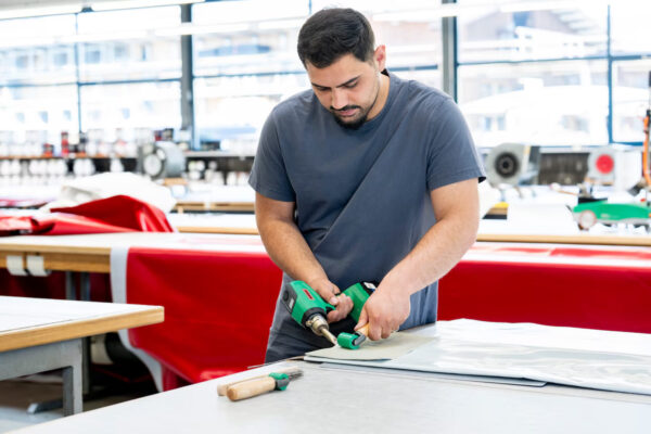 Operador utilizando soprador Leister NEXHEAT 300 A-LP para soldar lonas de PVC e coberturas