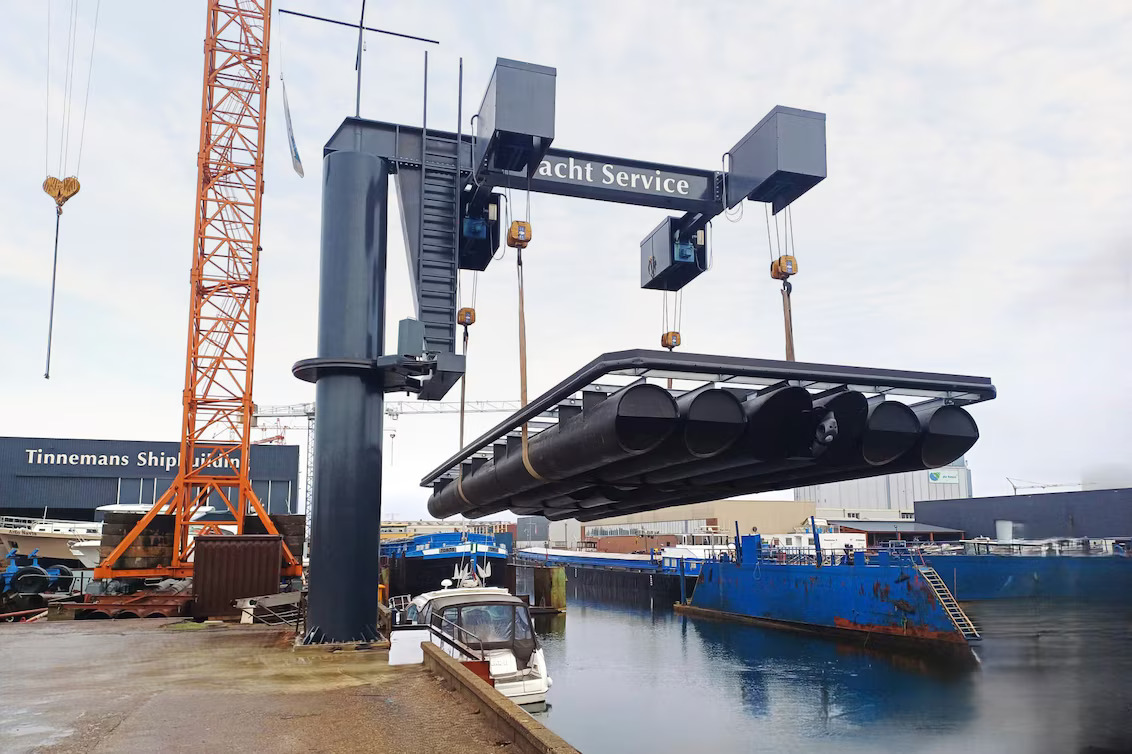 Guindaste içando a estrutura de flutuadores em PEAD que forma a base da casa flutuante, com módulos unidos por soldagem por extrusão usando ferramentas Leister