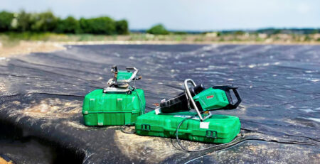Ferramentas Leister COMET 700 e WELDPLAST 605 GEO posicionadas sobre geomembrana de PEAD durante a instalação de impermeabilização de lago ornamental no Reino Unido