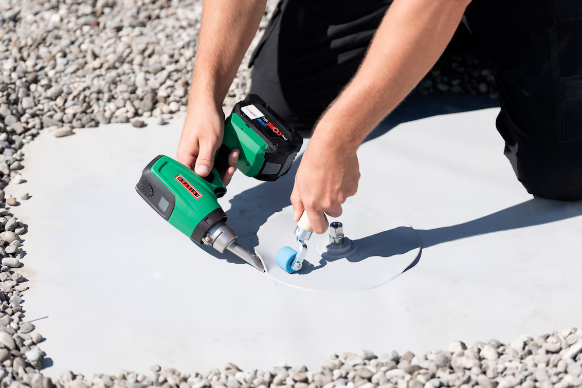 Técnico realizando soldagem de detalhe em membrana de telhado com a ferramenta a bateria Leister NEXHEAT 300 A-LP, oferecendo mobilidade total no serviço