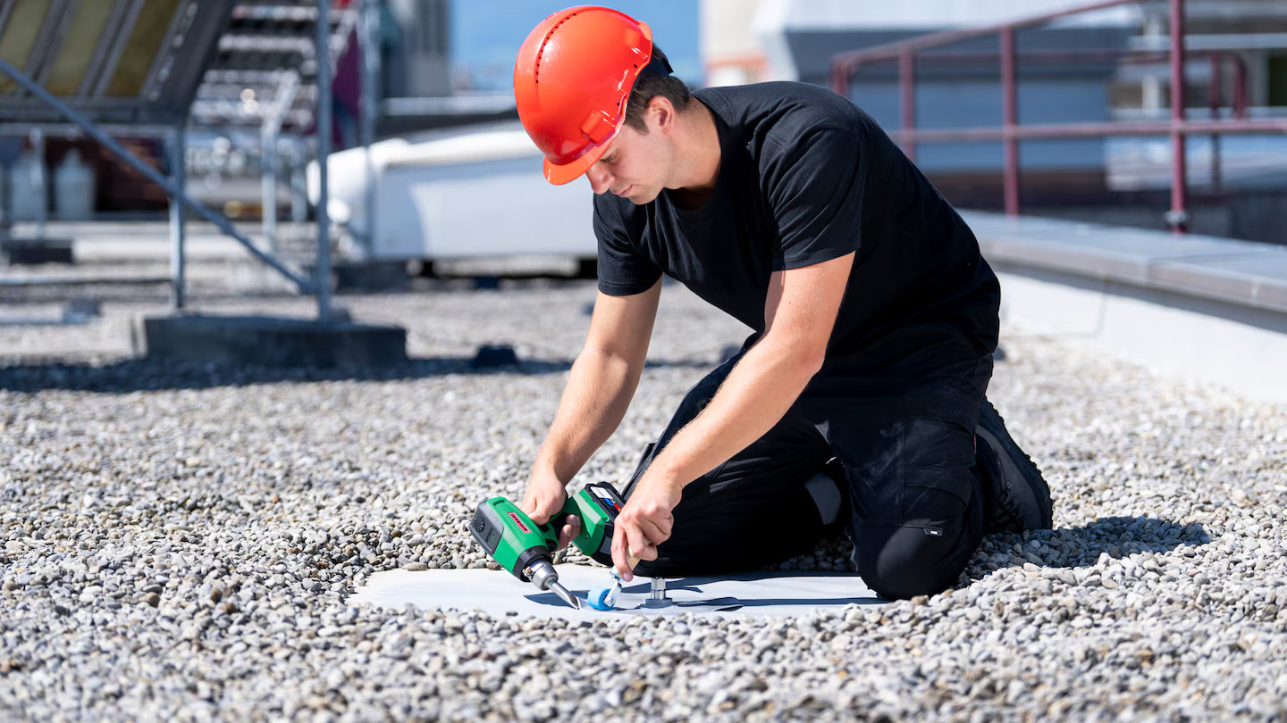 Técnico realizando soldagem de detalhe em membrana de telhado com a ferramenta a bateria Leister NEXHEAT 300 A-LP, oferecendo mobilidade total no serviço