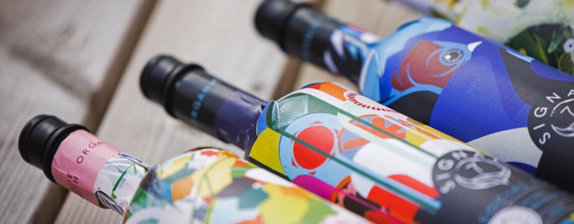 Garrafas Frugal Bottle de papel em close, com rótulos coloridos, mostrando a variedade de embalagens produzidas com precisão e aquecimento controlado Leister